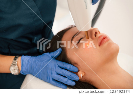 Getting photo rejuvenation procedure at cosmetology clinic. Woman is getting LPG hardware massage in beauty salon Getting photo rejuvenation procedure at cosmetology clinic. Woman is getting LPG hardware massage in beauty salon 128492374
