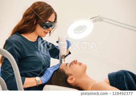 Conception of beauty. Getting photo rejuvenation procedure at cosmetology clinic 128492377