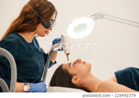 Conception of beauty. Getting photo rejuvenation procedure at cosmetology clinic 128492379