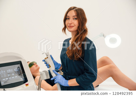 Modern device. Getting photo rejuvenation procedure at cosmetology clinic. Women in beauty salon 128492395