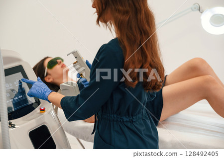 Preparing for photo rejuvenation procedure at cosmetology clinic. Women in beauty salon Preparing for photo rejuvenation procedure at cosmetology clinic. Women in beauty salon 128492405