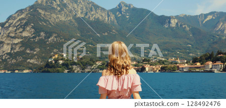 Summer vacation, beautiful woman tourist stands enjoying amazing sea landscape, mountains background 128492476