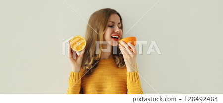 Nutrition, diet vegetarian concept. Happy healthy cheerful young woman with slices of orange fruits 128492483