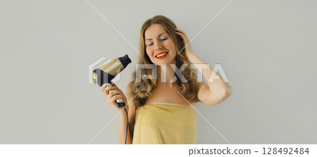 Body care, beautiful happy smiling young woman drying wet hair with bath towel after taking a shower 128492484
