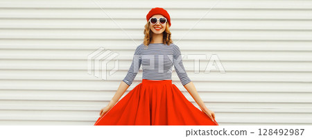 Beautiful happy smiling young woman posing in red skirt, french beret, glasses on white background 128492987