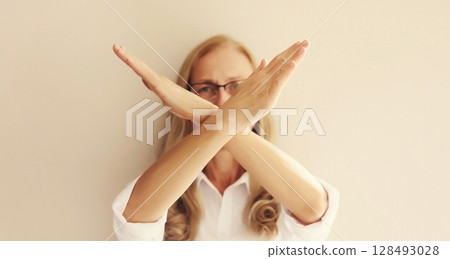 Woman shows stop, no or enough sign with palm of hand, refusal gesture, domestic violence 128493028