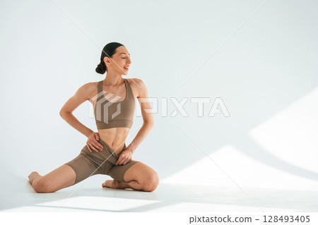 Khaki clothes. Young woman with slim body type is in the studio Khaki clothes. Young woman with slim body type is in the studio 128493405
