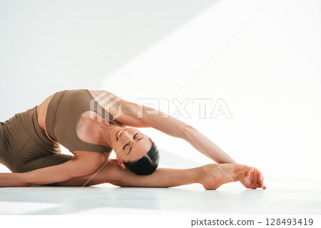 Flexibility of human body. Young woman is in fitness clothes in the studio Flexibility of human body. Young woman is in fitness clothes in the studio 128493419