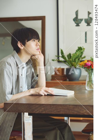 A man reading in the living room 128493474