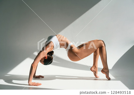 Young woman with slim body type is in fitness clothes in the studio Young woman with slim body type is in fitness clothes in the studio 128493518