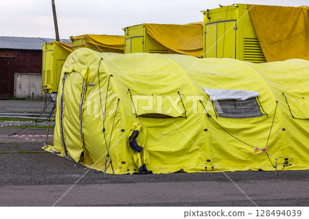 Large yellow tent with row of yellow trailers 128494039