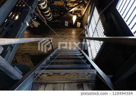 Steep wooden staircase and historic architectural beauty inside the Nagase House, a traditional house in Shirakawa-go 128494384