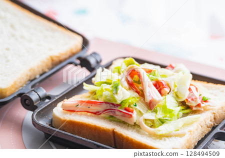 用蟹肉棒沙拉製作熱三明治 用蟹肉棒沙拉製作熱三明治 128494509