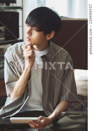 A man pondering in a room 128494557