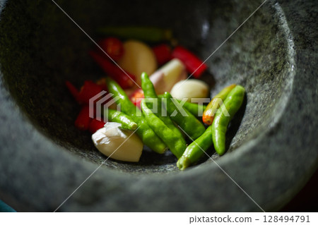 Chilli pepper in stone mortar Chilli pepper in stone mortar 128494791
