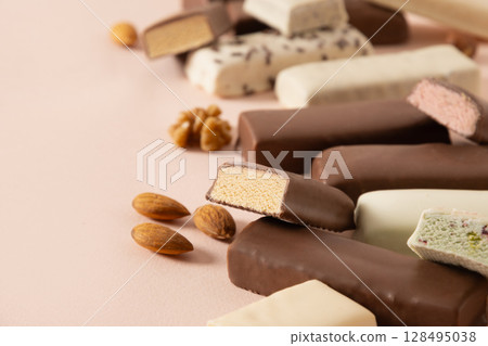 Different whey protein bars with various coatings and sprinkles on pink background. Close up. Copy space. 128495038