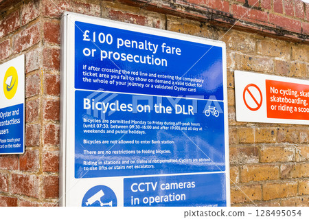 100 Pound Penalty Fare and Bicycle Policy Sign at Greenwich DLR Station, London Transport 128495054