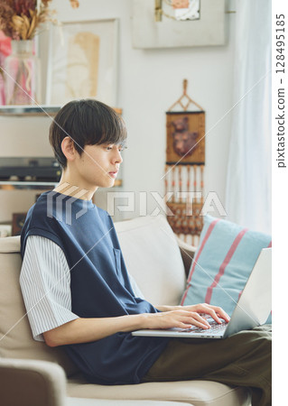 在客廳裡使用電腦的男士 在客廳裡使用電腦的男士 128495185