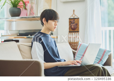 在客廳裡使用電腦的男士 在客廳裡使用電腦的男士 128495186