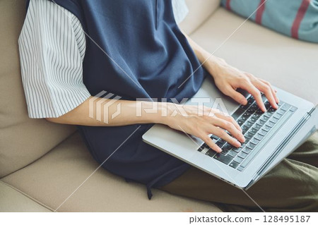 Hands of a man using a computer in the living room 128495187