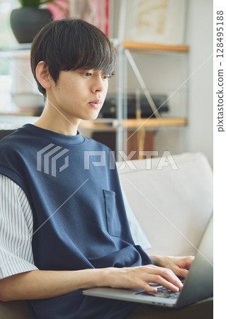 在客廳裡使用電腦的男士 在客廳裡使用電腦的男士 128495188