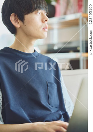 在客廳裡使用電腦的男士 在客廳裡使用電腦的男士 128495190