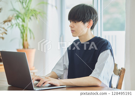 一名男子在餐廳使用電腦 一名男子在餐廳使用電腦 128495191