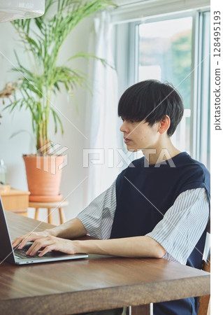 一名男子在餐廳使用電腦 128495193