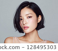 Beauty portrait of a young woman with short black bob hair and lustrous skin 128495303