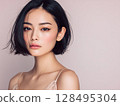 Beauty portrait of a young woman with short black bob hair and lustrous skin 128495304