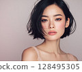 Beauty portrait of a young woman with short black bob hair and lustrous skin 128495305