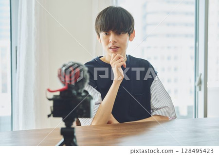 A young man shooting a video A young man shooting a video 128495423