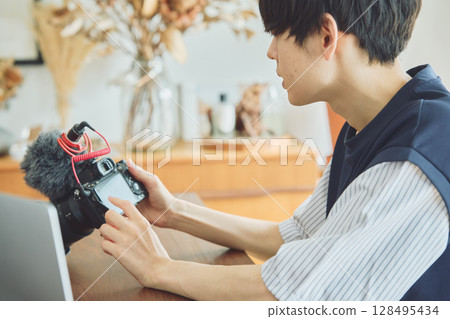 一名男子正在檢查影片片段 一名男子正在檢查影片片段 128495434