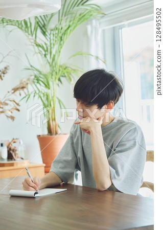Man taking notes in dining room 128495502