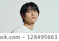 The silent gaze of a clear-skinned young man in a white T-shirt | Studio shot 128495663