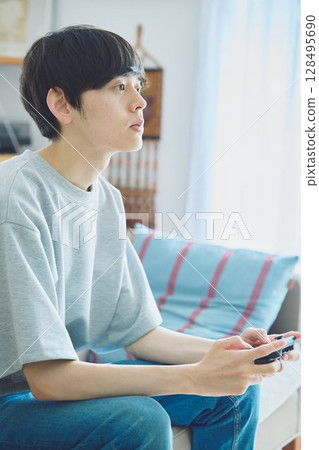 男人在客廳玩遊戲 128495690