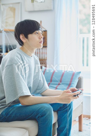 男人在客廳玩遊戲 128495691