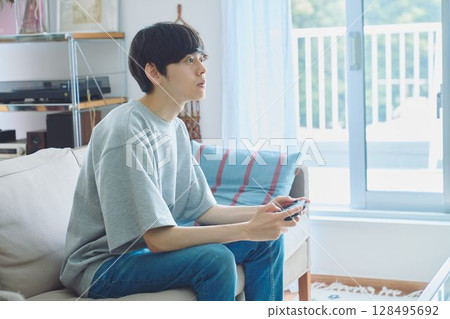 男人在客廳玩遊戲 128495692