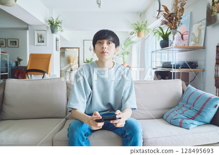 男人在客廳玩遊戲 128495693