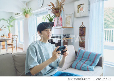 Man playing games in the living room 128495698