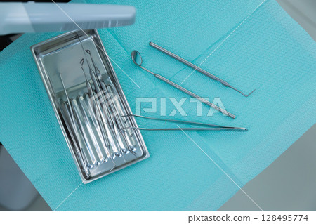 A Close-Up View of Dental Instruments on a Sterilized Tray, Ready for Use in a Professional Dental Clinic Setting for Dental Care and Oral Health Procedures 128495774