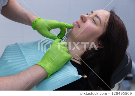 A Professional Aesthetician Administering Injectable Treatment to Enhance Facial Contours in a Comfortable Clinical Setting A Professional Aesthetician Administering Injectable Treatment to Enhance Facial Contours in a Comfortable Clinical Setting 128495869