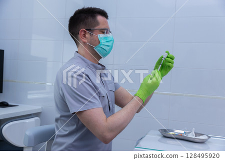 Healthcare Professional Preparing a Vaccine in a Clean Medical Environment with Proper Safety Gear Including Gloves and a Mask for Patient Care and Safety Healthcare Professional Preparing a Vaccine in a Clean Medical Environment with Proper Safety Gear Including Gloves and a Mask for Patient Care and Safety 128495920