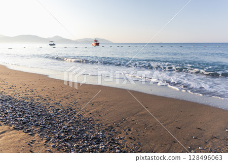 A picturesque beach setting with smooth sands, scattered pebbles A picturesque beach setting with smooth sands, scattered pebbles 128496063