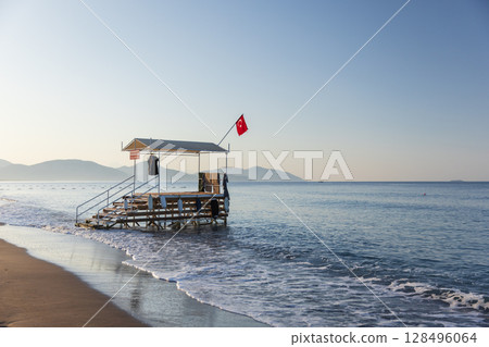 A small water sports dock near the shore with gentle waves A small water sports dock near the shore with gentle waves 128496064