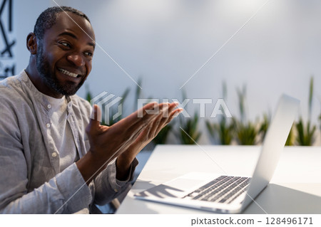 African American businessman participating in video call, discussing project performance in office 128496171