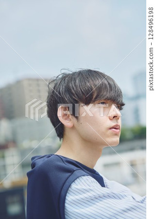 Man standing on balcony of apartment 128496198