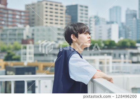 Man standing on balcony of apartment Man standing on balcony of apartment 128496200
