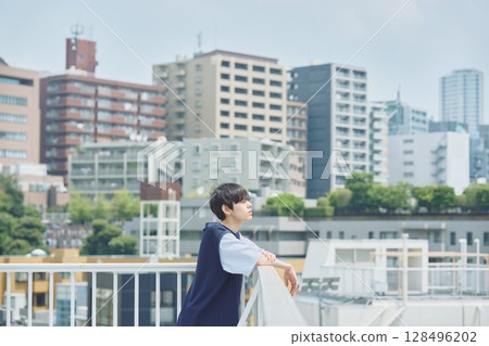 Man standing on balcony of apartment Man standing on balcony of apartment 128496202