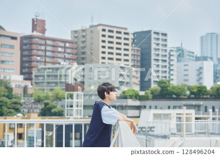 Man standing on balcony of apartment 128496204